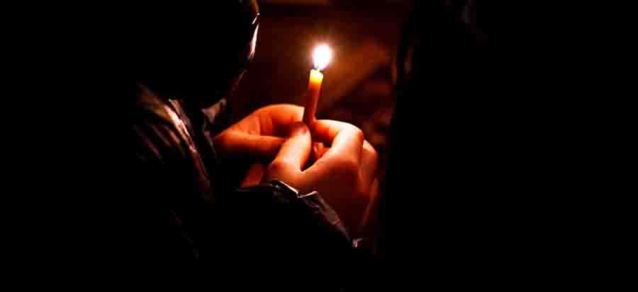 Мужчина ставит свечу. Человек молится. Женщина молится. Мужчина молится в храме. Мужчина в храме со свечой.